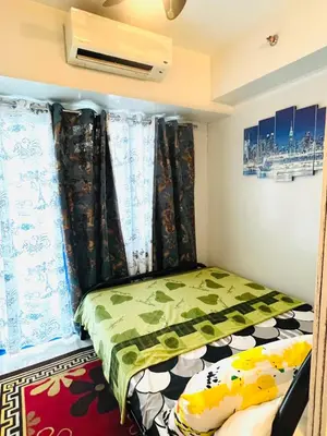 a small bed in a room with curtains at Sea Residences Elegant Place by Paul in Manila