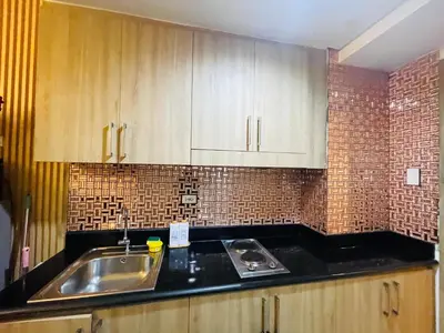 a kitchen with wooden cabinets and a sink at City Point at Shore Residences in Manila