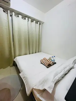 a bed in a room with two pillows on it at City Point at Shore Residences in Manila