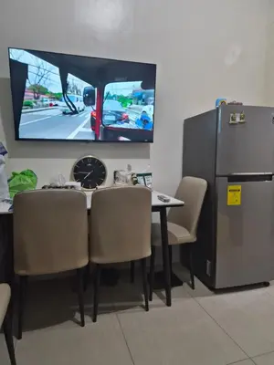 a room with a table and chairs and a tv at ZEN 2 SHORE RESIDENCES Tower A in Manila