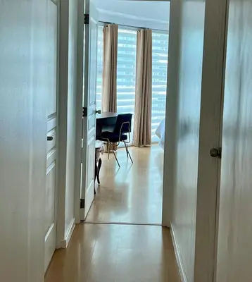 a hallway with a view of a living room with a table at Charming 2-BR Condo in BGC in Manila
