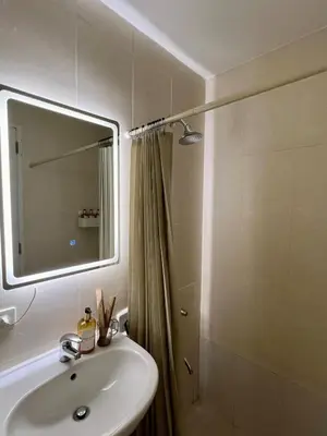 a bathroom with a sink and a shower and a mirror at Charming 2-BR Condo in BGC in Manila