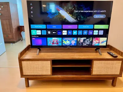 a flat screen tv sitting on top of a wooden stand at Charming 1-BR in BGC in Manila
