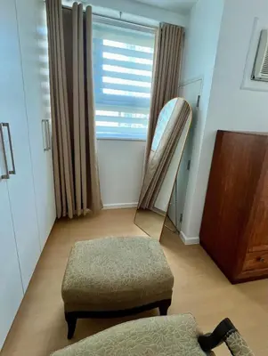a living room with a chair and a ottoman at Charming 1-BR in BGC in Manila