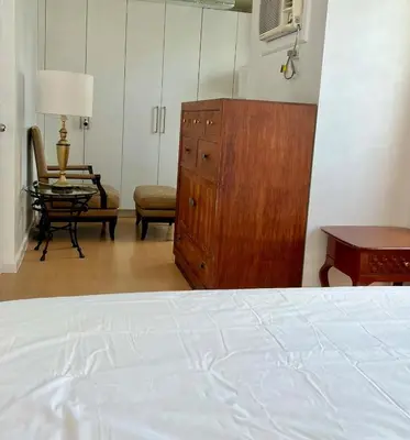 a bedroom with a bed and a dresser and a chair at Charming 1-BR in BGC in Manila