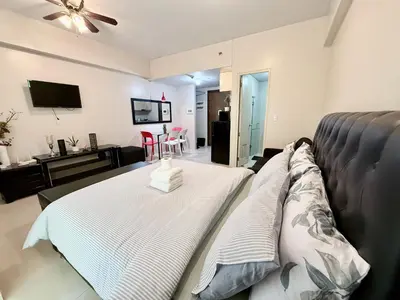a living room with a couch and a television at Apartment near Airport at One Palm Tree Villas in Manila