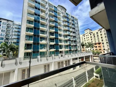 an apartment balcony with a large building in the background at Apartment near Airport at One Palm Tree Villas in Manila
