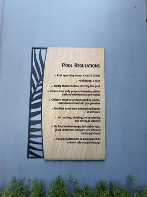 a sign on the side of a blue wall at Apartment near Airport at One Palm Tree Villas in Manila