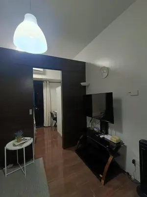 a living room with a tv and a table and a light at AIR RESIDENCES MAKATI Staycation in Manila