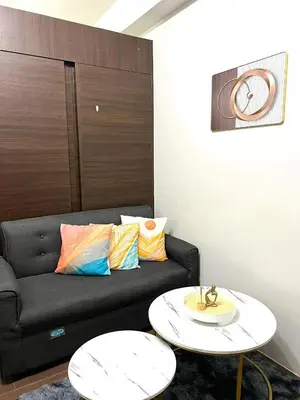 a living room with a couch and a table at AIR RESIDENCES MAKATI Staycation in Manila