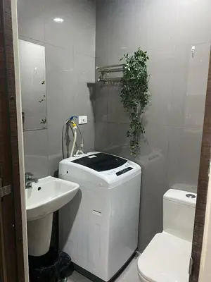 a white bathroom with a toilet and a sink at AIR RESIDENCES MAKATI Staycation in Manila