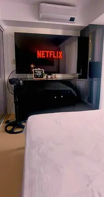 a bed in a hotel room with a netflix sign at AZURE RESIDENCES near International AIRPORT MANILA in Manila