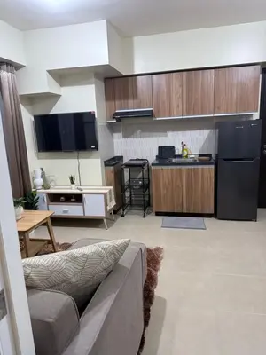 a living room with a couch and a kitchen at 1BR Staycation at Avida Towers SM Sucat in Manila
