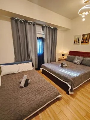 a bedroom with two beds and a window at Holland Park staycation in Jalang