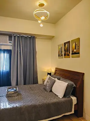 a bedroom with a bed and a chandelier at Holland Park staycation in Jalang