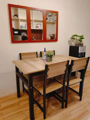 a wooden table with two chairs and a mirror at Holland Park staycation in Jalang