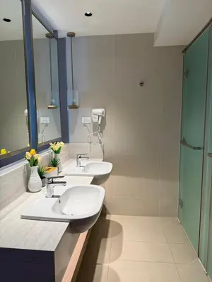 a bathroom with two sinks and a shower at Metro Suites at Novotel Suites Acqua in Manila