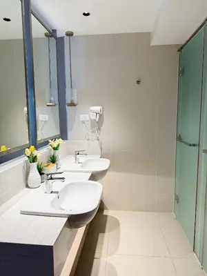 a bathroom with two sinks and a shower at Metro Suites at Novotel Suites Acqua in Manila