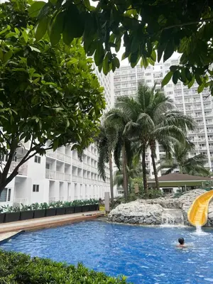 a person in the water in a pool with a slide at DMV Trinity Stay in Manila