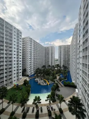 arial view of a resort with a pool and palm trees at DMV Trinity Stay in Manila