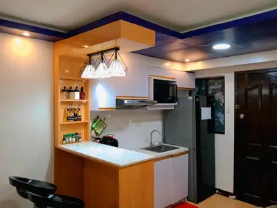 a kitchen with a sink and a black refrigerator at Gabrielle Staycation in Imus