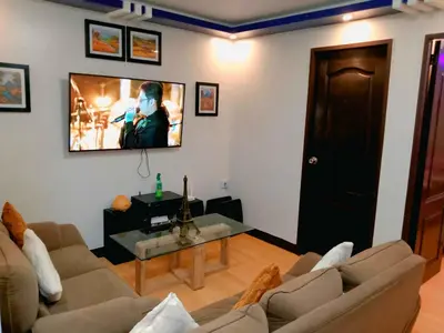 a living room with a couch and a tv on the wall at Gabrielle Staycation in Imus