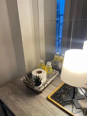 a bathroom counter with a roll of toilet paper and a lamp at Casa California by AC Haven in Shore Residences near MOA Pasay City in Manila