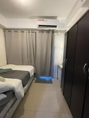 a small room with two beds and a closet at Casa California by AC Haven in Shore Residences near MOA Pasay City in Manila