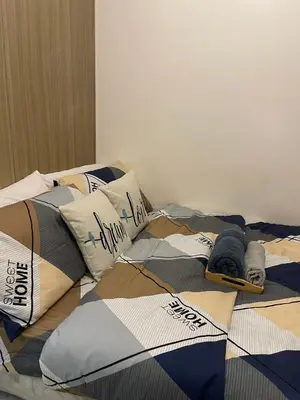 a bed with a comforter and pillows on it at Casa California by AC Haven in Shore Residences near MOA Pasay City in Manila