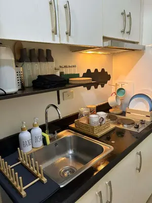 a kitchen with a sink and a counter top at Cozy City Escape - Jazz Residences in Manila