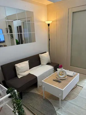 a living room with a couch and a coffee table at Cozy City Escape - Jazz Residences in Manila