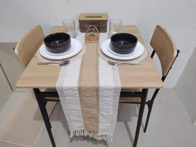 a wooden table with plates and bowls on it at Cozy City Escape - Jazz Residences in Manila