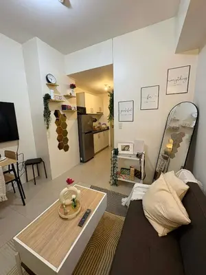 a living room with a couch and a table at Cozy City Escape - Jazz Residences in Manila