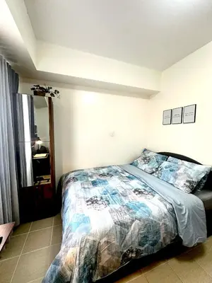 a bedroom with a bed and a large window at Candice Empire Garden in Manila