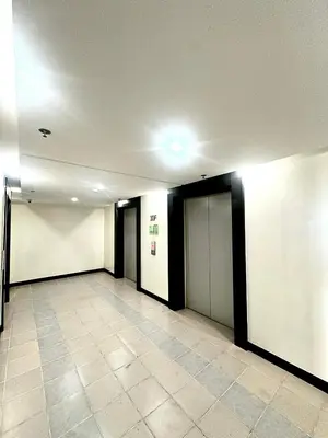 an empty hallway with white walls and a tile floor at Candice Empire Garden in Manila