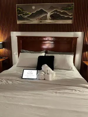 a bed with two towels and a book on it at Azure Luxury Condo in Manila
