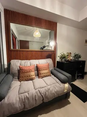 a couch in a living room with a large mirror at Azure Luxury Condo in Manila