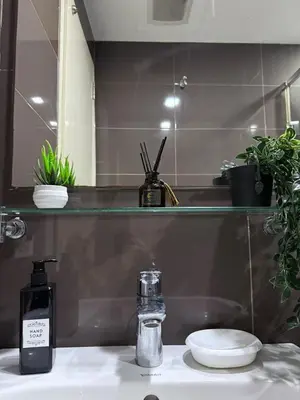 a bathroom sink with a soap dispenser and a mirror at Modern Condo in Makati with Stylish City Escape in Manila