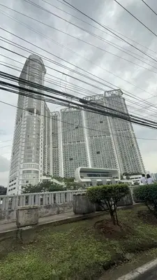 a large building with tall buildings in the background at Modern Condo in Makati with Stylish City Escape in Manila