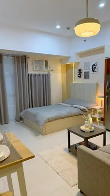 a bedroom with a bed and a living room at A Studio Unit in McKinley Near Venice Grand Canal Mall in Manila