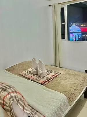 a bedroom with a bed with two pillows and a window at Jeff staycation in Manila