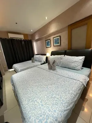 a bedroom with two beds and a couch at Jeff staycation in Manila