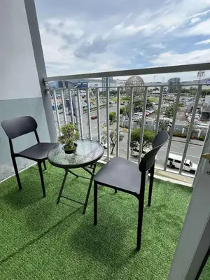 a balcony with a table and chairs and a view of a city at Jeff staycation in Manila