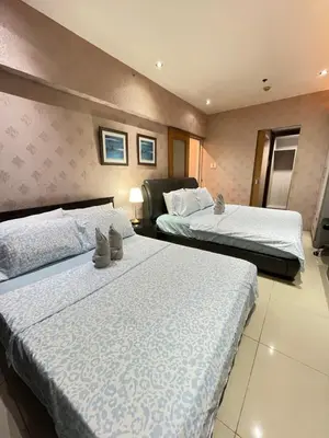 a hotel room with two beds with white sheets at Jeff staycation in Manila