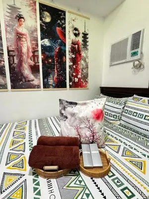 a bedroom with a bed with posters on the wall at Near Vista Mall Taguig BGC with Overlooking Veranda Netflix and Pay Parking in Manila