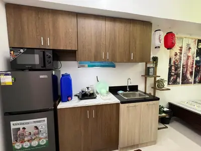 a small kitchen with a refrigerator and a sink at Near Vista Mall Taguig BGC with Overlooking Veranda Netflix and Pay Parking in Manila
