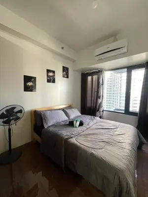 a bedroom with a large bed and a window at Hailar Property Management in Manila