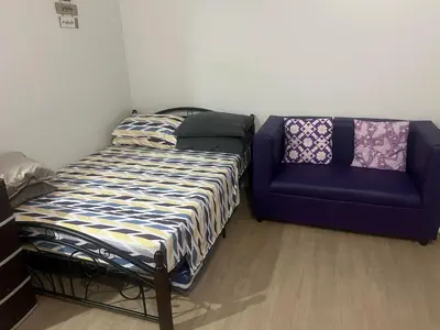 a bed and a couch in a room at Park Residences 201 - Sta Rosa Laguna