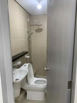 a bathroom with a toilet and a sink at Cozy oozy apartment in Manila