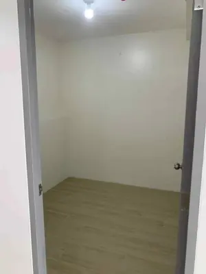 an open door to a white room with a wooden floor at Cozy oozy apartment in Manila